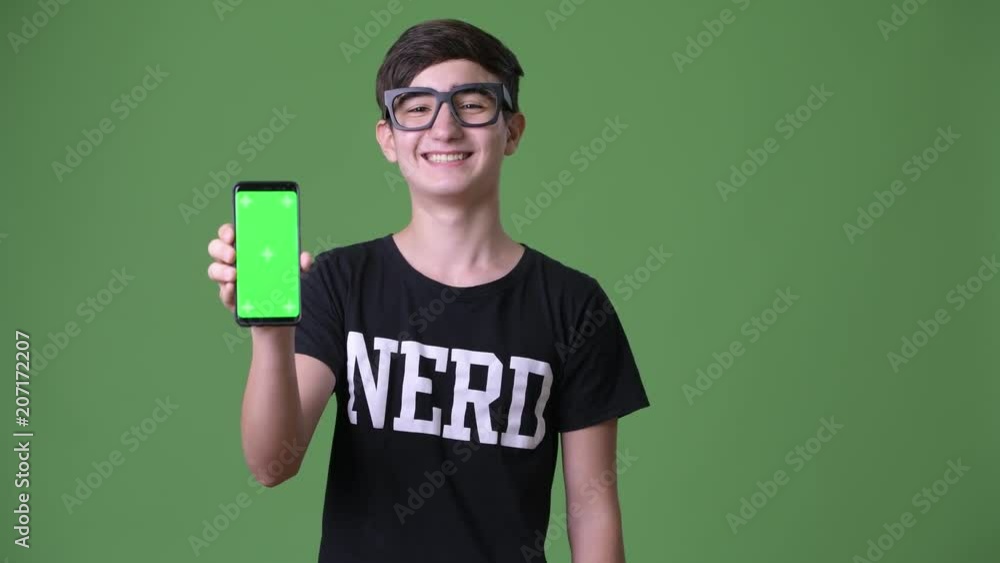 Young handsome Iranian teenage boy against green background Young handsome Iranian teenage boy against green background