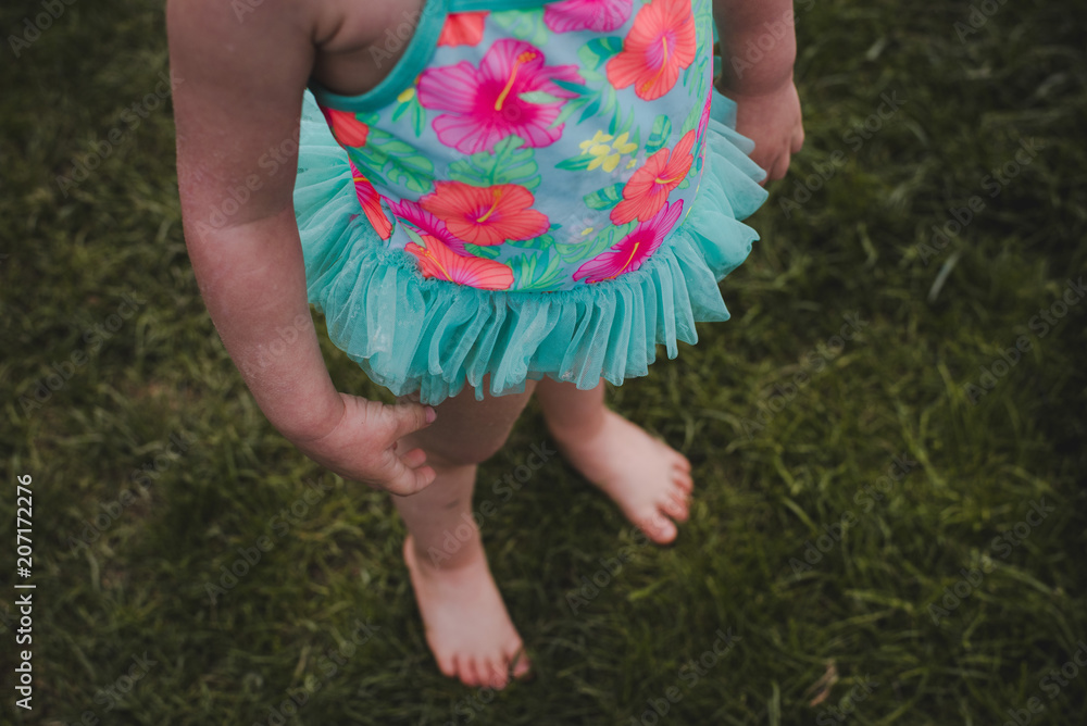 Little girl wearing a swimming suit and standing Little girl wearing a swimming suit and standing
