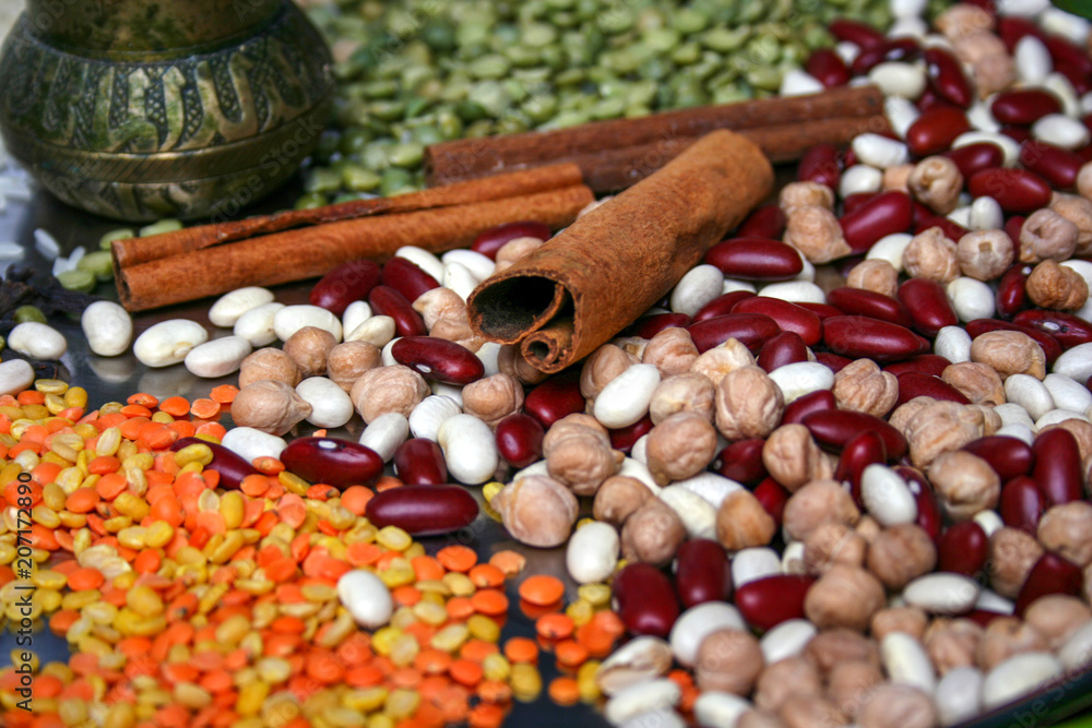 Cinnamon sticks, green peas, spices, lentils, legumes on plate. Close up