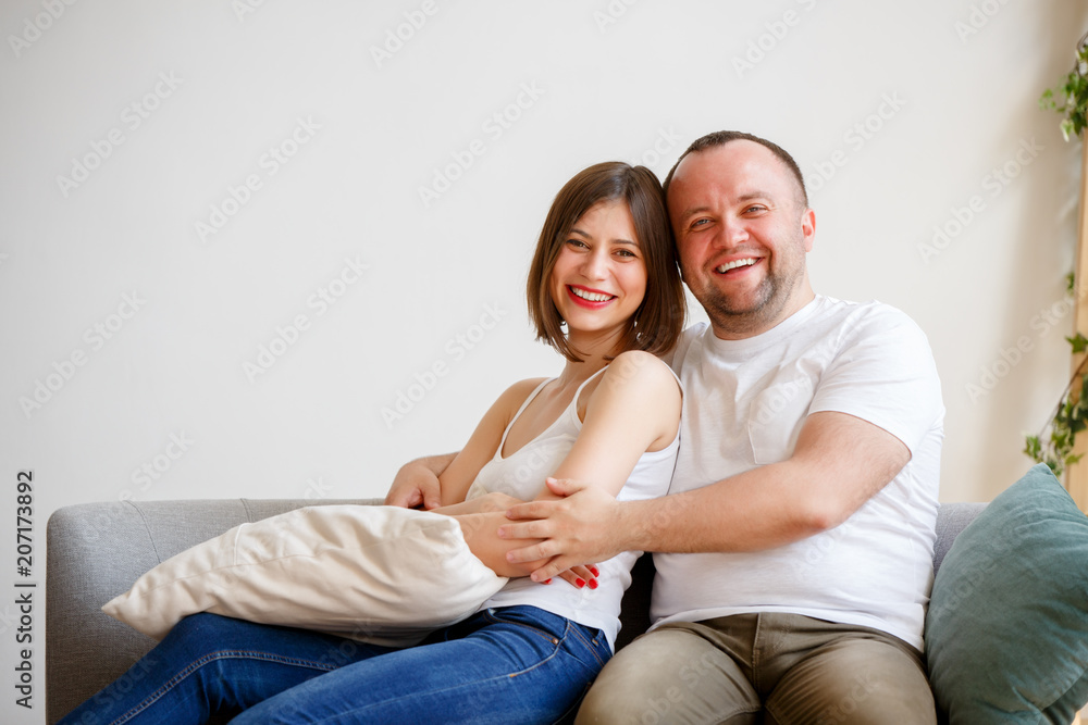Image of smiling married couple sitting on sofa Image of smiling married couple sitting on sofa
