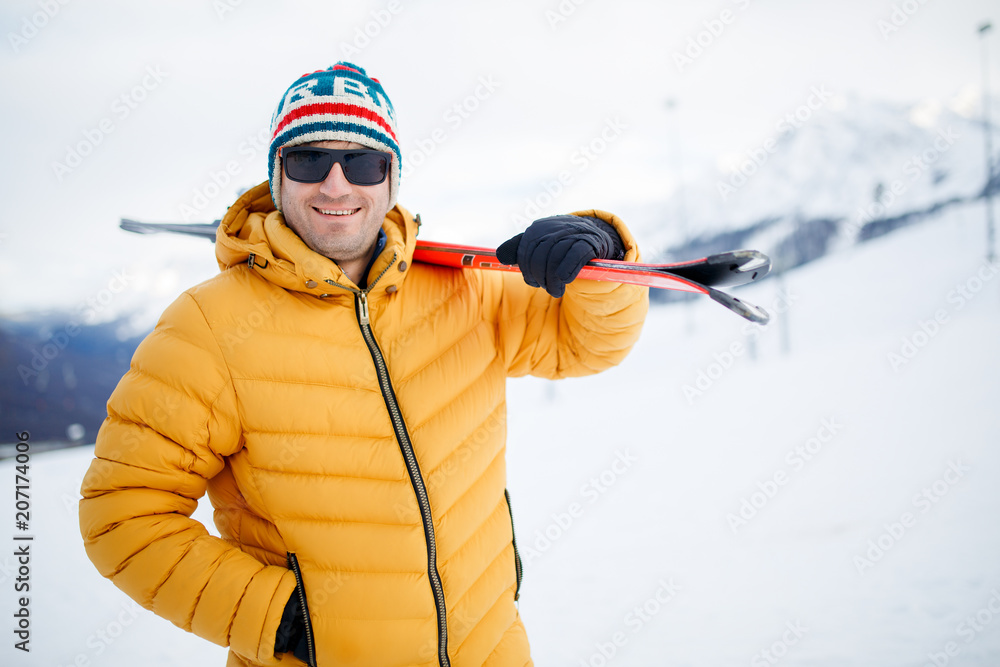Photo of smiling man with mountain skis