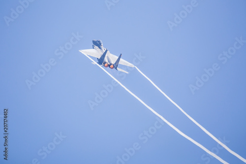 Vapour trails from the wings of an F-15C Eagle from the 48th Fighter Wing as it overflies the runway at RAF Lakenheath after a training sortie. photo