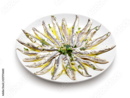 Delicate Marinated anchovies with parsley, olive oil and vinegar isolated on white background.