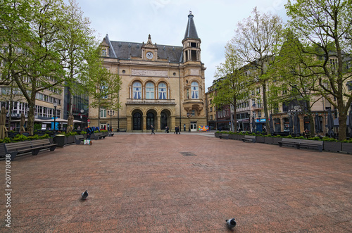 Luxembourg, Luxembourg-MAY 01, 2018: Spring urban landscape photo. Beautiful Place d'Armes square with Cercle Municipal (Cercle Cite Luxembourg) at the background. Cloudy May morning
