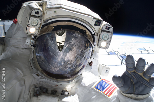 Close up of an astronaut waving hi to the camera.Elements of this image furnished by NASA.