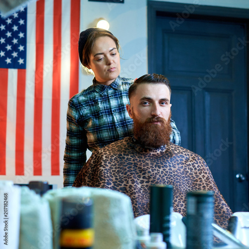 Photo of hipster man getting haircut by hairdresser