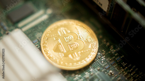 Bitcoin mining process - gold coin on computer circuit board with bitcoin processor and microchips. Electronic currency, internet finance rypto currency concept. Golden Bitcoin Cryptocurrency photo