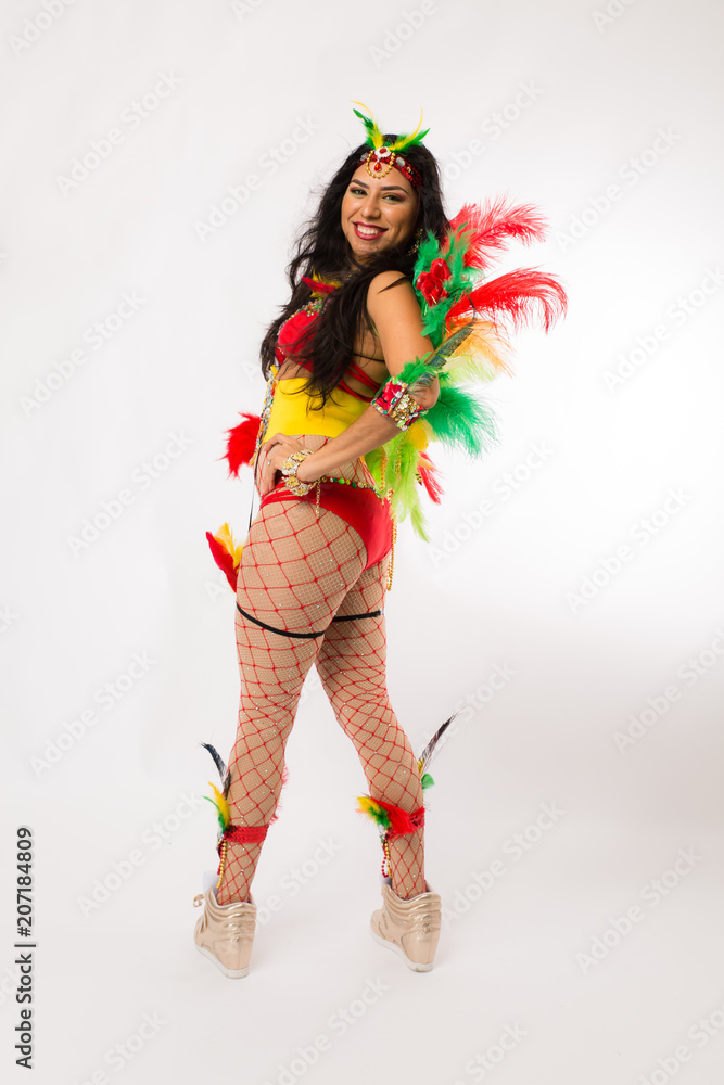 Very fit young hispanic woman in Carnaval costume and athletic shoes posing on clean white background Very fit young hispanic woman in Carnaval costume and athletic shoes posing on clean white background