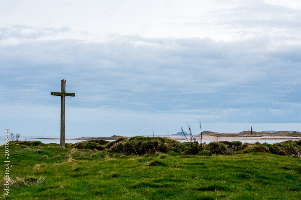 A wooden cross, on a grassy island A wooden cross, on a grassy island