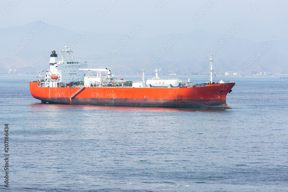 Red LPG tanker at anchor while calm weather.