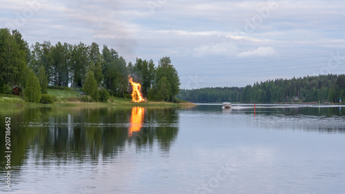 Finland. Midsummer feast, bonfire, boat and lake