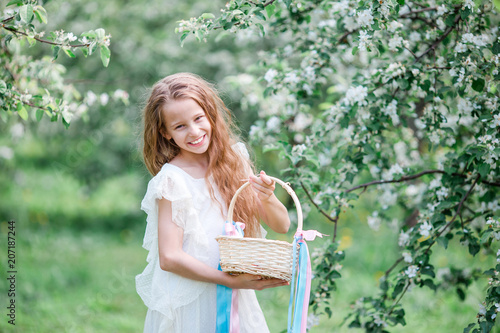 Adorable little girl in blooming apple garden on beautiful spring day © travnikovstudio