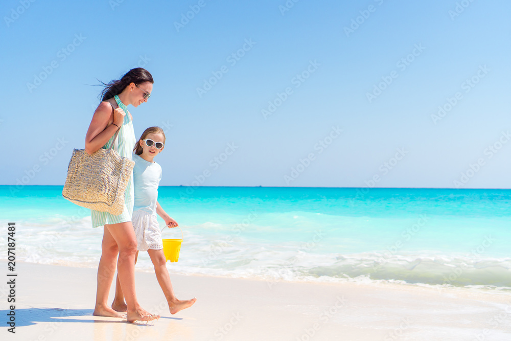 Little adorable girl and young mother at tropical beach Little adorable girl and young mother at tropical beach
