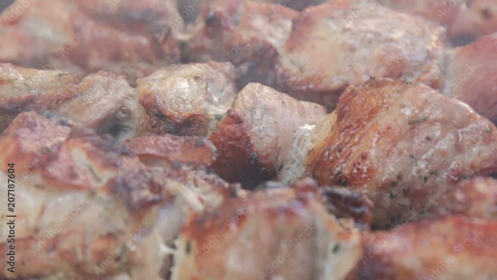 Close-up marinate shashlyk on a barbecue. Smoke over roast beef on BBQ grill. Appetizing shish kebab on skewers. Close-up marinate shashlyk on a barbecue. Smoke over roast beef on BBQ grill. Appetizing shish kebab on skewers.