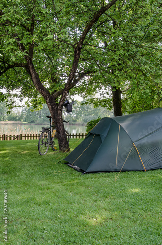 Tent and bicycle near romantic lake