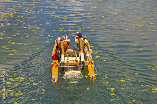 Two man ride with floating pedal bicycle boats across the lake photo