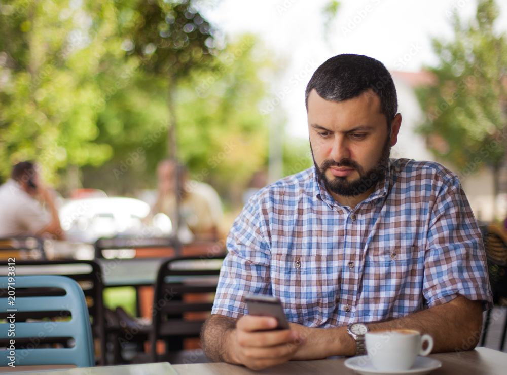 Handsome young man with phone in cafe. Handsome young man with phone in cafe.