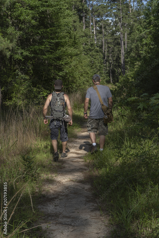 Fototapeta premium Two Male Hikers Going Into National Forest