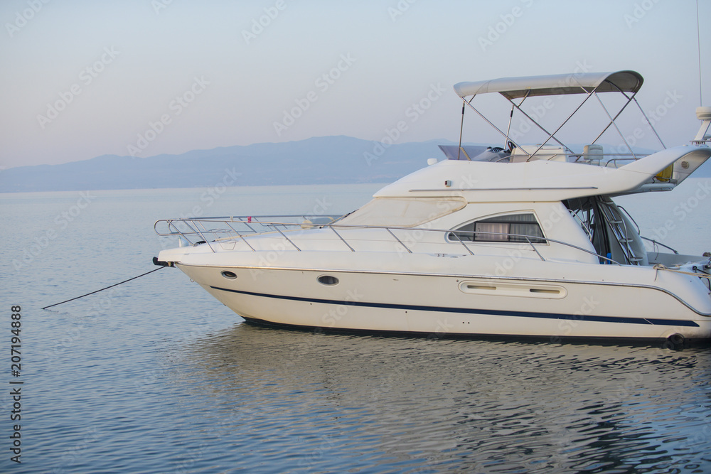 Yacht at sea coast on sunny blue sky. Yachting and sailing adventure. Luxury travel and voyage on boat. Summer vacation in tropical resort. Water transport and marine vessel