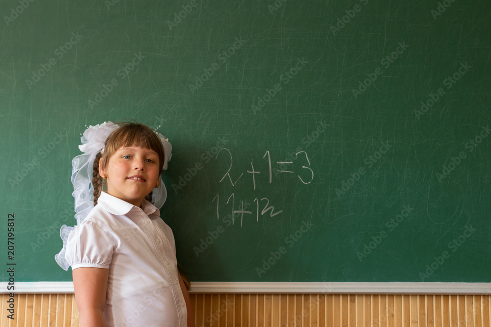 The girl is writing on the board, solving complex equations. The girl is writing on the board, solving complex equations.