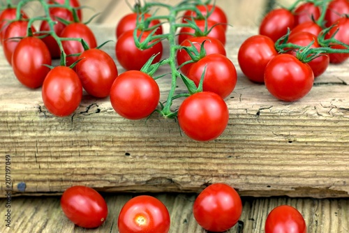 Healthy food, tomatoes and vegetables concept: fresh ripe cherry tomatoes on old wooden background.