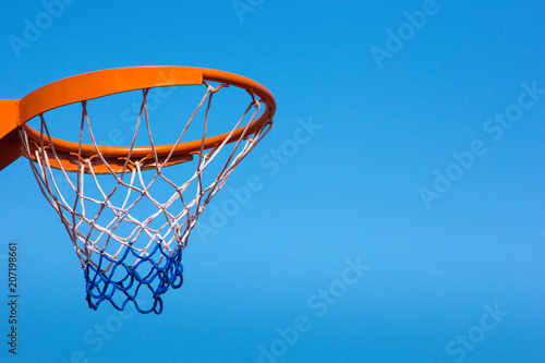 Basketball hoop against the blue sky, close-up