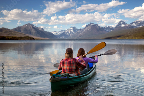 Adventurous traveling couple rowing a boat on a perfect scenic lake in a beautiful national park
