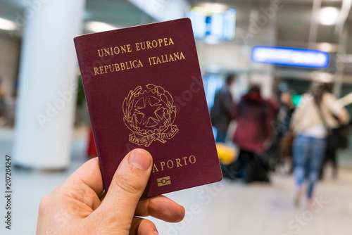 man holding italian passport in the airport