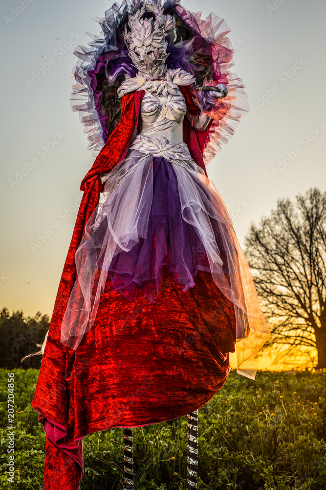 Fairy tale woman on stilts in bright fantasy stylization. Fine art outdoor photo.