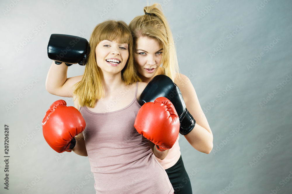 Two women friends wearing boxing gloves Two women friends wearing boxing gloves