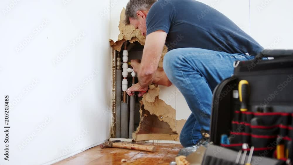 Domestic Plumber With Tools Repairing Leaking Pipe Domestic Plumber With Tools Repairing Leaking Pipe