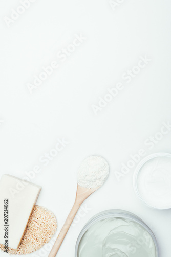 flat lay with soap, sponge, spoon, clay masks in containers and clay powder isolated on white surface