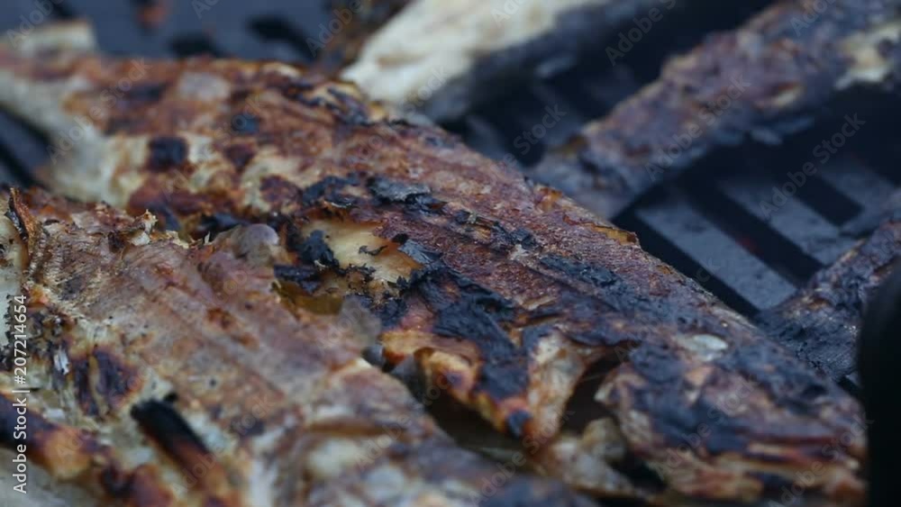 Grilling trout fish on barbecue - close-up view Grilling trout fish on barbecue - close-up view