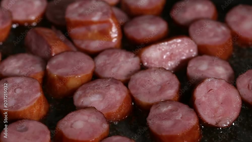 Frying pork sausages in pan with sunflower oil - close up view Frying pork sausages in pan with sunflower oil - close up view