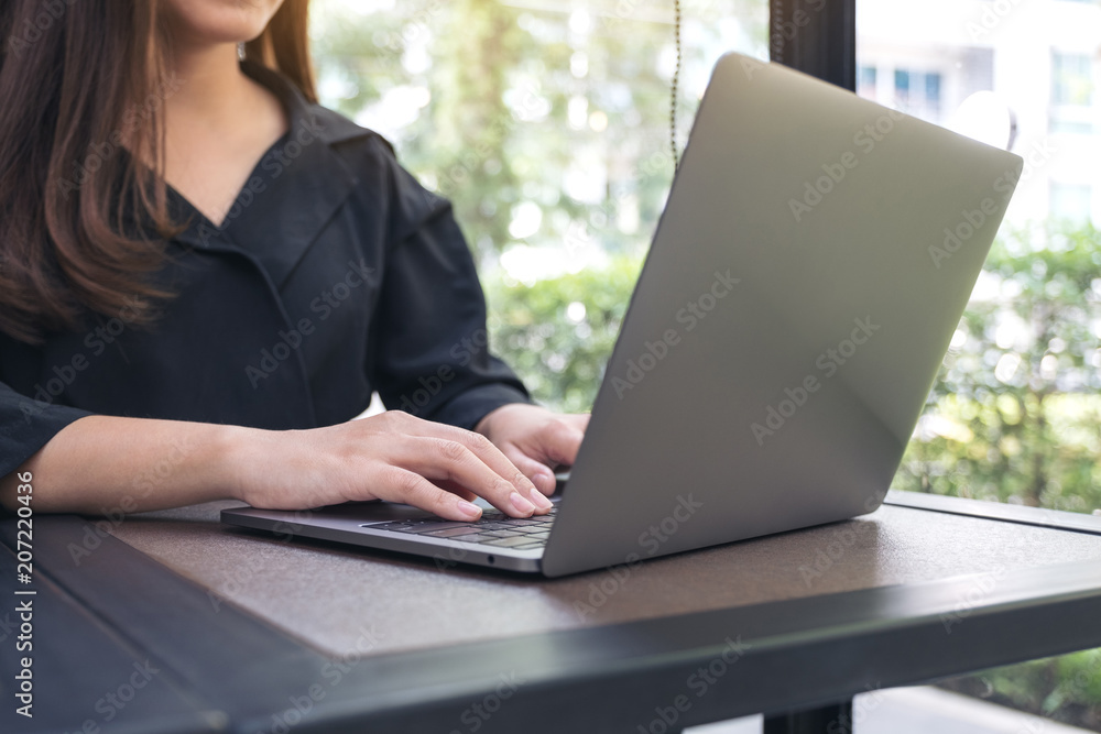 Closeup image of a business woman working and typing on laptop keyboard in office Closeup image of a business woman working and typing on laptop keyboard in office