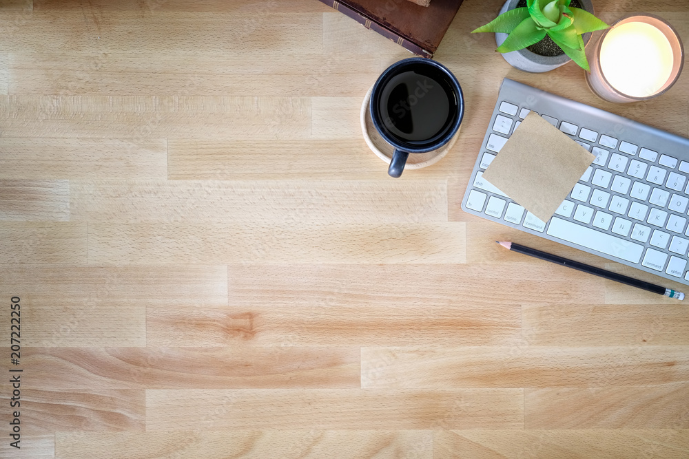 Office desk wooden table with keyboard computer, cup of coffee and flower. Top view with copy space Office desk wooden table with keyboard computer, cup of coffee and flower. Top view with copy space