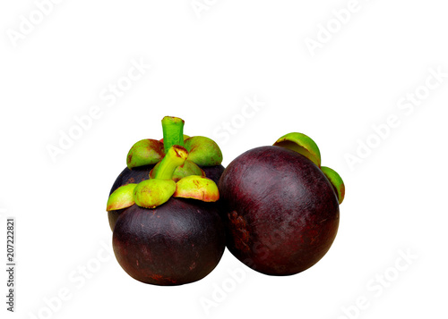 Whole mangosteen showing purple skin isolated on white background with space. Tropical fruit from Thailand. The queen of fruits. Asia fresh fruit market concept. Natural source of tannin and xanthones