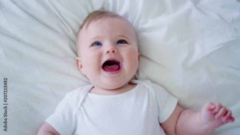 Overhead Shot Of Baby Boy Lying On Bed And Laughing Overhead Shot Of Baby Boy Lying On Bed And Laughing