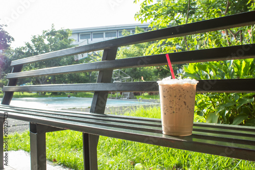 Coffee cool moment the sun is low. On a steel chair in the park photo