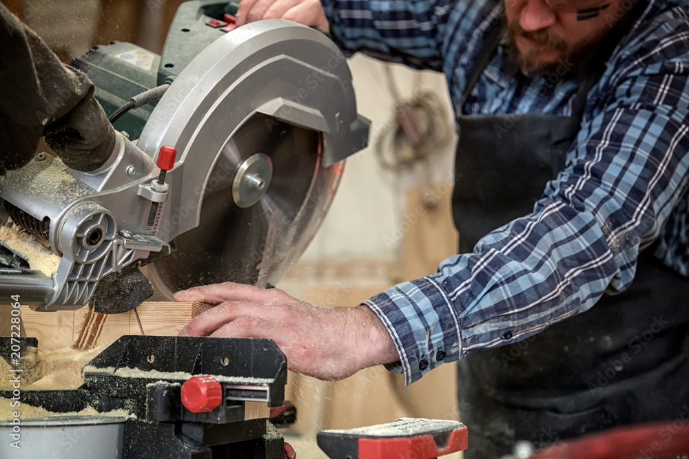 Carpenter work with circular saw for cutting boards, the man sawed bars, construction and home renovation, repair and construction tool Carpenter work with circular saw for cutting boards, the man sawed bars, construction and home renovation, repair and construction tool