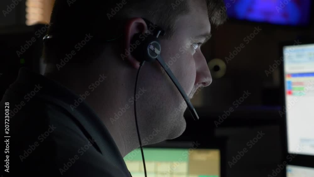 A 911 dispatcher works at his computer station at a control center to help respond to emergency calls.