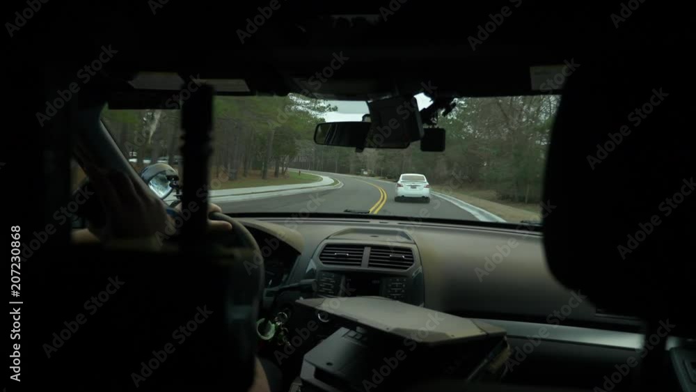 Police officer driving his patrol car to enforce traffic laws. Police officer driving his patrol car to enforce traffic laws.