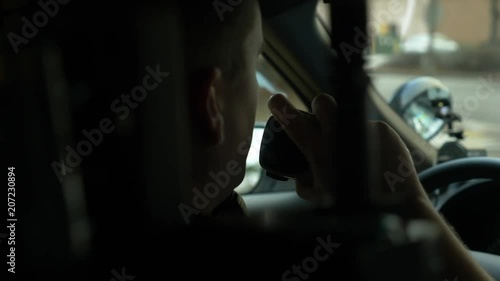 Police officer driving his patrol car to enforce traffic laws.