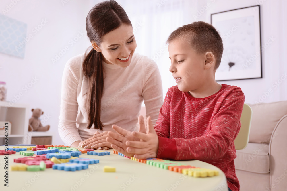 Young nanny playing with cute little boy at home Young nanny playing with cute little boy at home