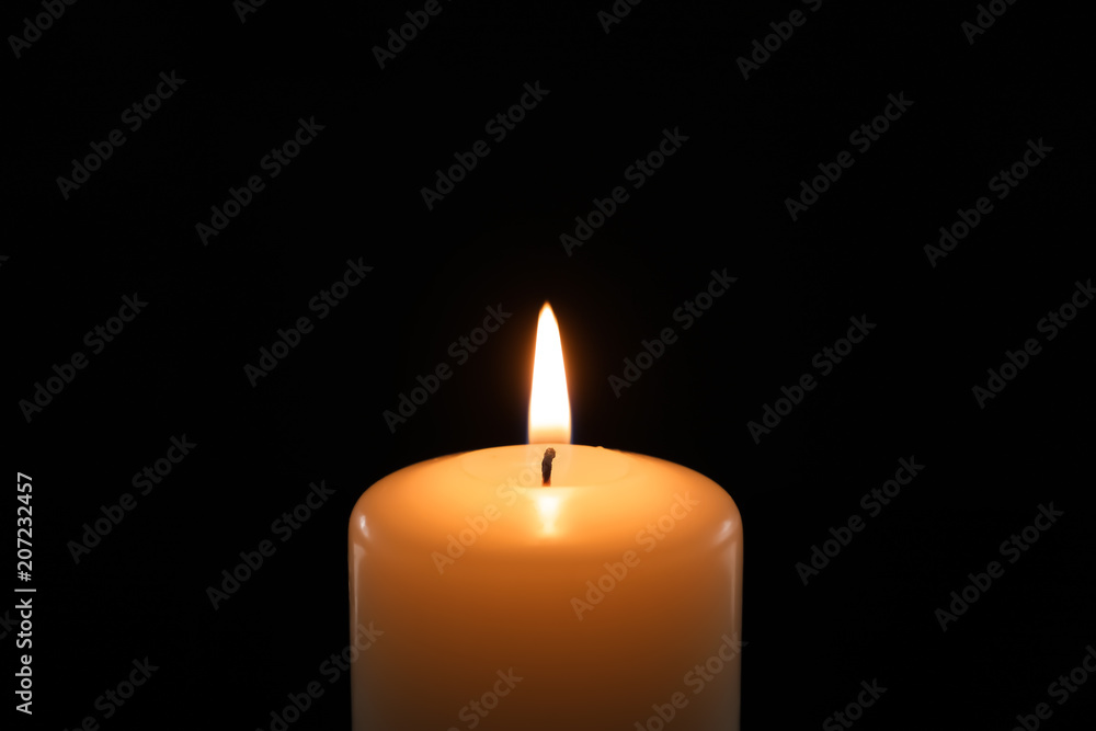 Wax candle burning on black background, closeup Wax candle burning on black background, closeup