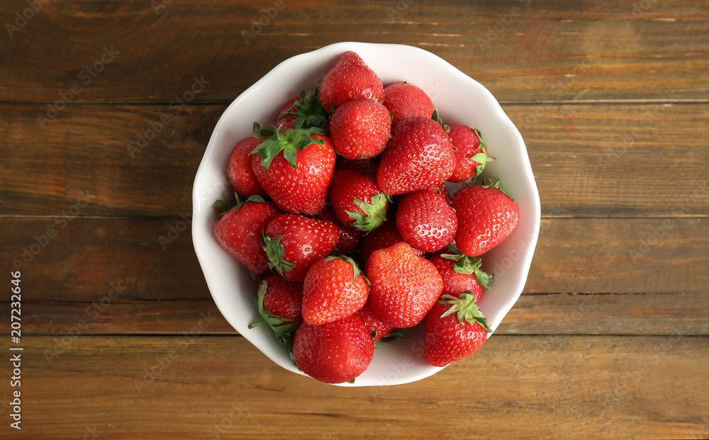 Bowl with ripe red strawberries on wooden background, top view Bowl with ripe red strawberries on wooden background, top view