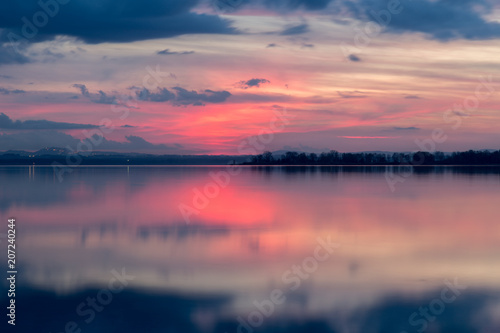 Perfectly symmetric reflection of sunset on a lake, with warm 