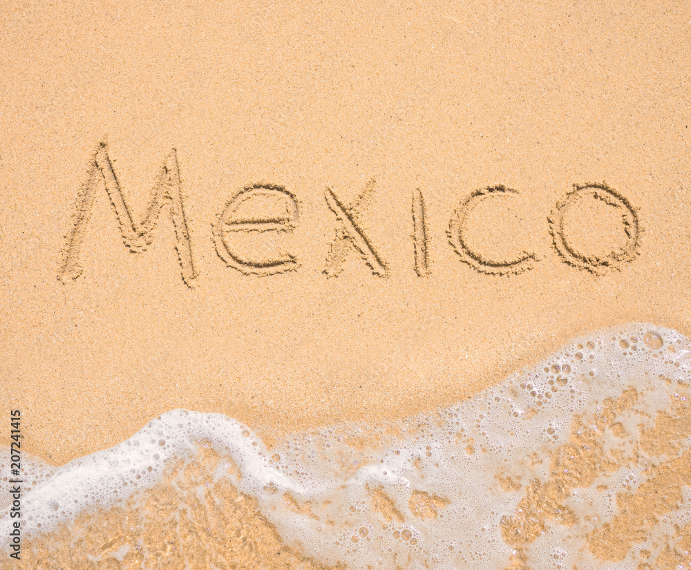 Fototapeta premium The word Mexico written in the sand on beach