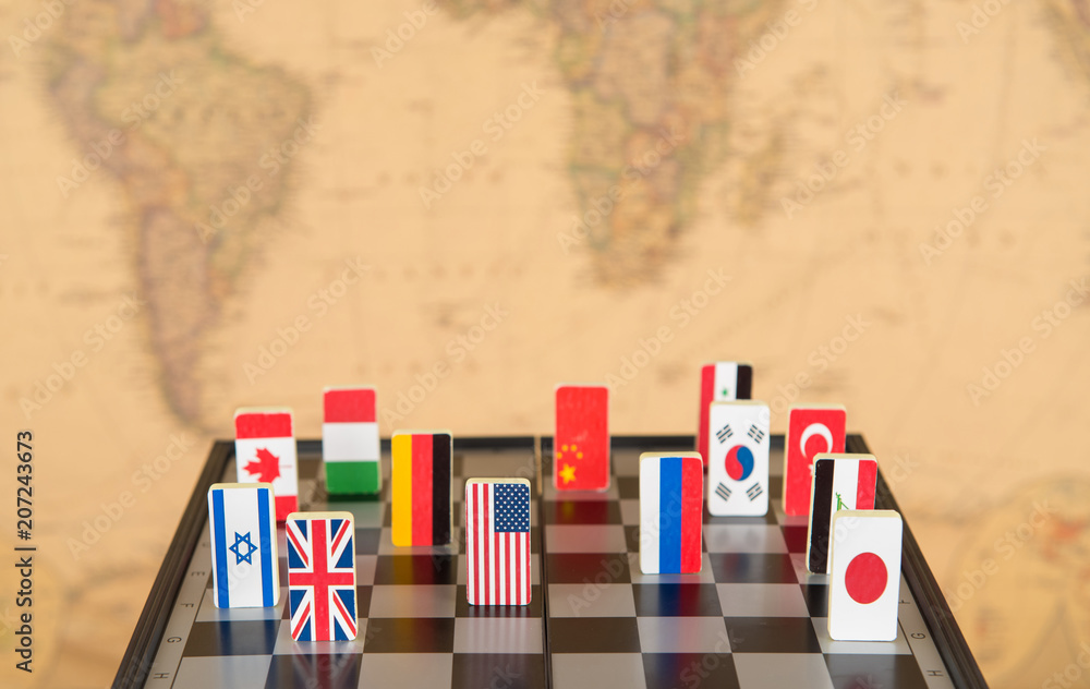 symbols of countries on the chessboard against against the background the political map of the world. Conceptual photo, political games. 