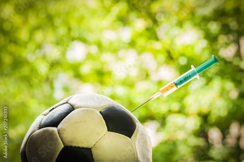 Soccer ball gets an injection / Soccer ball gets an injection with a syringe, doping in sports.